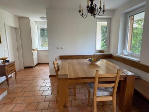 a dining room with a wooden table and chairs at Zbilje Lake house in Medvode