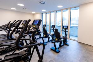 a gym with treadmills and ellipticals in a building at Hotel und Therme NOVA in Köflach