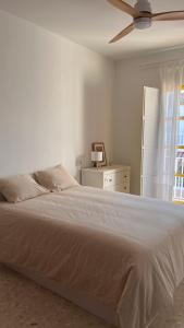 a bedroom with a large bed with a ceiling fan at Villa Alhelí del Aljarafe in Mairena del Aljarafe +15 photos