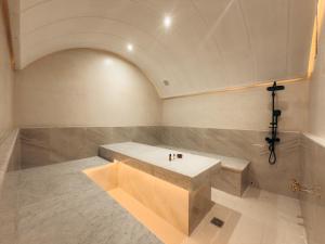 a bathroom with a bench in the middle of a room at Maison Azen - Moroccan Luxury Stay in Essaouira