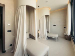 a bedroom with a bed and a window with curtains at Maison Azen - Moroccan Luxury Stay in Essaouira