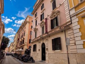 a building on a street with a motorcycle parked in front at Alessandro Palace & Bar in Rome
