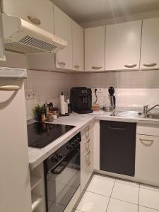 a kitchen with white cabinets and a black stove top oven at MarkthofApartment in Erfurt