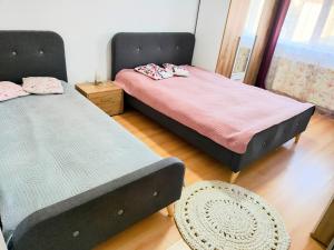 a bedroom with two beds and a chair at Cuibul Practic in Oradea