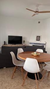 a dining room with a table and white chairs at Villa Alhelí del Aljarafe in Mairena del Aljarafe