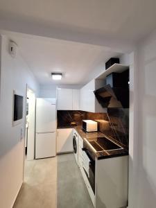 a kitchen with white cabinets and a stove top oven at Joy's apartment in Markopoulo