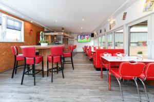 a restaurant with red chairs and a bar at Reit- und Ferienhof Maack in Neuharlingersiel