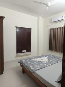 a room with a bed and a flat screen tv at Bn Homestay in Mysore