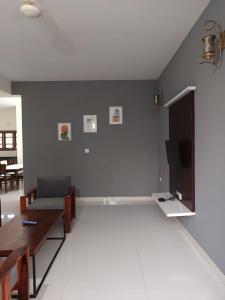 a living room with a couch and a tv at Bn Homestay in Mysore