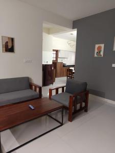 a living room with a couch and a coffee table at Bn Homestay in Mysore