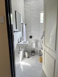 a white bathroom with a sink and a toilet at Sedudu Turn Cottages in Maun