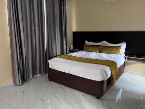 a bedroom with a bed with a black headboard at Sedudu Turn Cottages in Maun