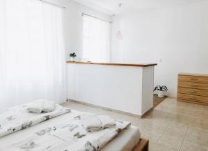 a white bedroom with two beds and a desk at Spálený mlýn v Národním parku Podyjí in Znojmo