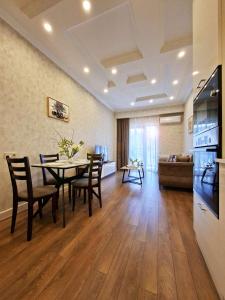 a dining room and living room with a table and chairs at Spacious Riverside Apartment in Central Tbilisi with Balcony in Tbilisi City +15 photos