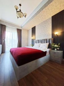 a bedroom with a large bed with a red blanket at Spacious Riverside Apartment in Central Tbilisi with Balcony in Tbilisi City