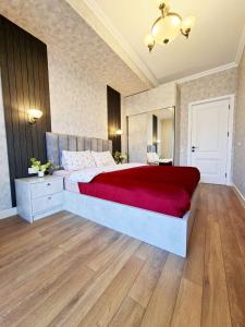a bedroom with a large bed with a red blanket at Spacious Riverside Apartment in Central Tbilisi with Balcony in Tbilisi City