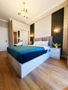 a bedroom with a large bed with a blue blanket at Spacious Riverside Apartment in Central Tbilisi with Balcony in Tbilisi City