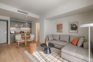 a living room with a couch and a table at Leon by Zoia Living in Piraeus