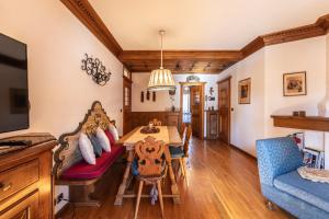 a dining room with a table and a couch at Casa Amalia, with panoramic terrace in Cortina dʼAmpezzo