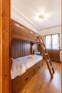 a bedroom with a bunk bed with a ladder at Casa Amalia, with panoramic terrace in Cortina dʼAmpezzo