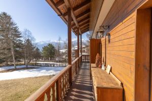 a wooden porch with a bench on the side of a house at Casa Amalia, with panoramic terrace in Cortina dʼAmpezzo