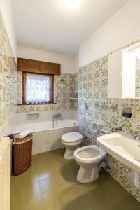a bathroom with a toilet and a tub and a sink at Casa Amalia, with panoramic terrace in Cortina dʼAmpezzo +12 photos