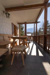 a wooden deck with a table and benches on it at Casa Amalia, with panoramic terrace in Cortina dʼAmpezzo
