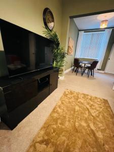 a living room with a large television and a table at Belles Haven in Belfast