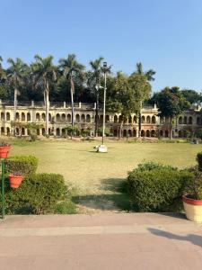 a large building with a large yard with plants at Awara Hostels and Dormitory in Lucknow