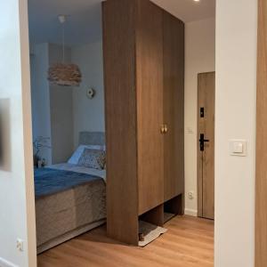 a bedroom with a bed and a wooden cabinet at Park View Olszynki Park in Rzeszów