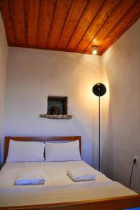 a bedroom with a bed with a wooden ceiling at Anéza house tinos in Skaládhos