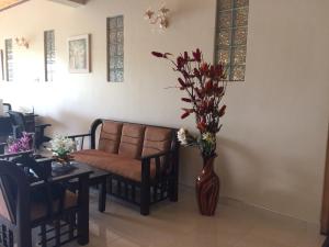 a living room with a couch and a vase with flowers at GG Lodge Mirissa in Mirissa
