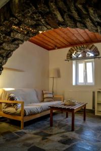 a living room with a bed and a table at Anéza house tinos in Skaládhos