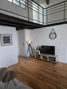 a living room with a flat screen tv and wooden floors at Aigues-Vives Appartement in Aigues-Vives