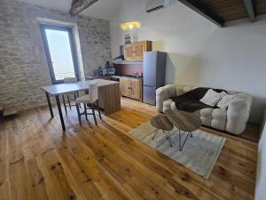 a kitchen and living room with a table and a couch at Aigues-Vives Appartement in Aigues-Vives
