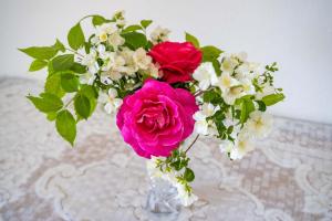 a vase filled with pink and white flowers on a table at Minas House in Mesochórion