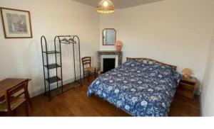 a bedroom with a bed and a desk and a shelf at Maison des chateaux in Bléré