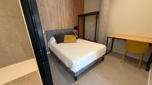 a small bedroom with a bed and a desk at Bormujos Suites Sevilla in Bormujos
