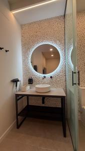 a bathroom with a sink and a mirror at Bormujos Suites Sevilla in Bormujos +24 photos