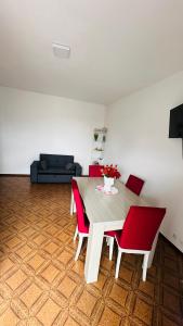 a dining room with a table and red chairs at sole in Novara