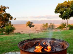 a fire pit in a field with flames at Excelsior Country House in Porterville +12 photos