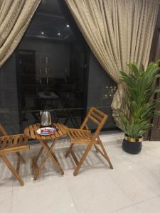a patio with two chairs and a table and a plant at Royale Rest Suites in Rāmkot