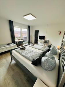 a large bedroom with two beds in a room at Die Schlafstube - Apartments und mehr in Neuharlingersiel