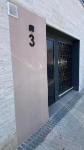 a door with the number three on the side of a building at Bormujos Suites Sevilla in Bormujos