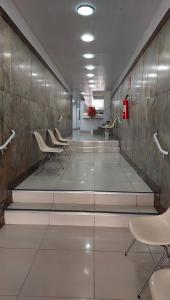 a waiting room with chairs and stairs in a building at Hotel Pampulha Palace in Belo Horizonte