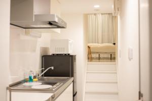 a small kitchen with a sink and a refrigerator at stella stay in Imari