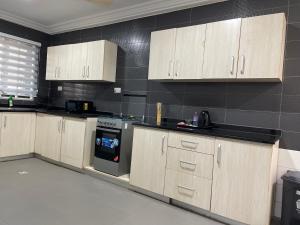 a kitchen with wooden cabinets and a stove at ENA Apartments in Apenkwa