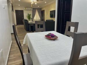 a dining room table with a bowl of flowers on it at ENA Apartments in Apenkwa +11 photos