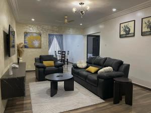 a living room with a black leather couch and chairs at ENA Apartments in Apenkwa