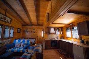a living room with a couch and a kitchen in a cabin at Campeggio Beaulard in Beaulard